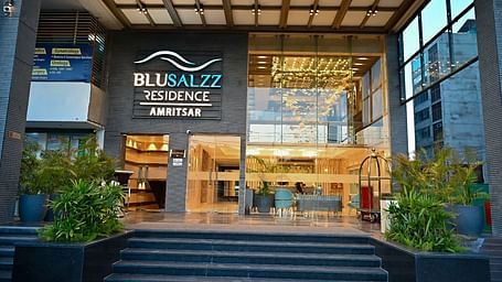 Hotel entrance with neatly arranged plants on both sides at BluSalzz Residence, Amritsar.